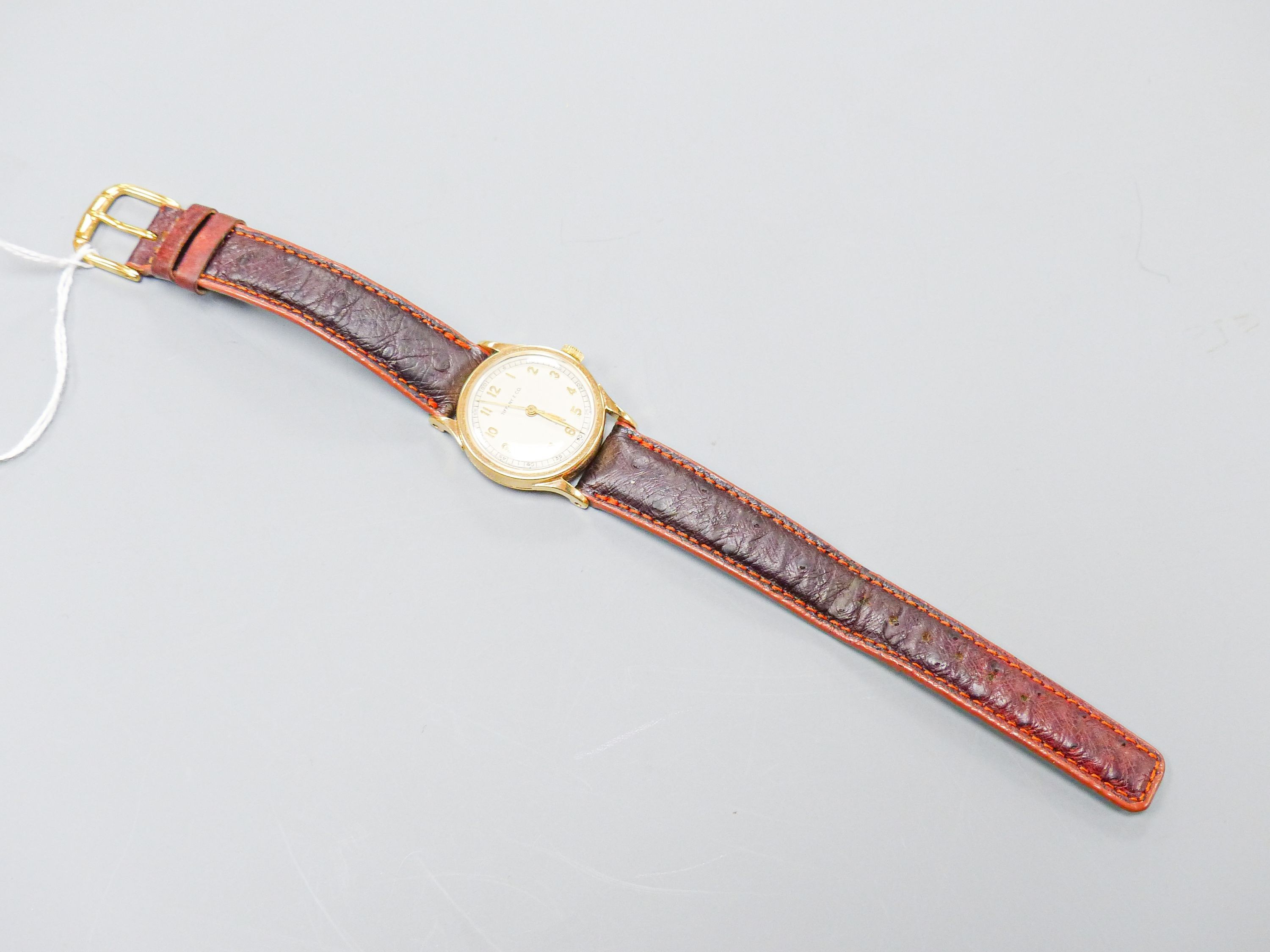 A lady's 14k Tiffany & Co manual wind wrist watch, on associated leather strap, case diameter 27mm, gross weight 28.8 grams.
